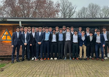 Members of the Triangle fraternity pose outside their fraternity house